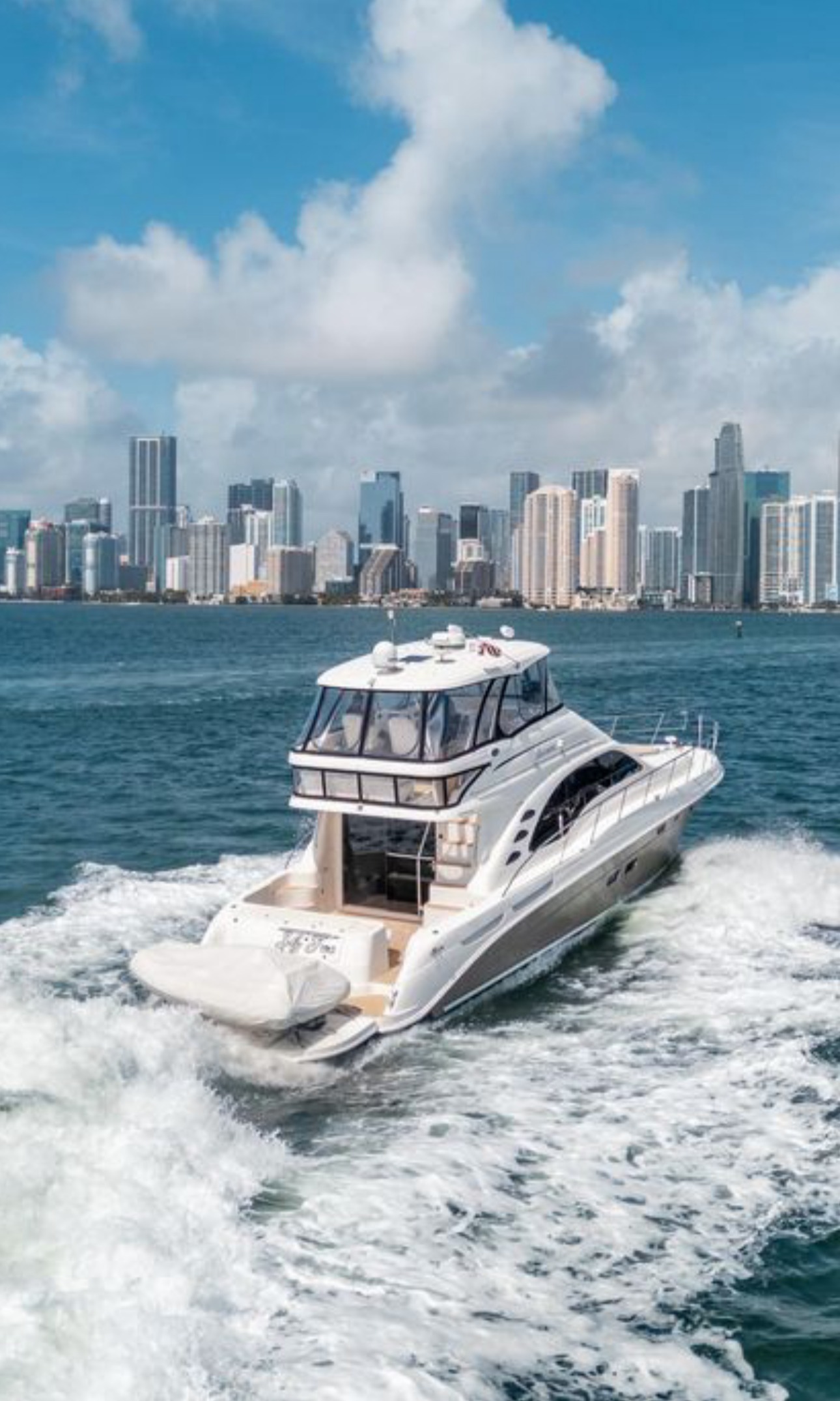 Luxury motor yacht cruising in Nassau Bahamas waters with city skyline behind