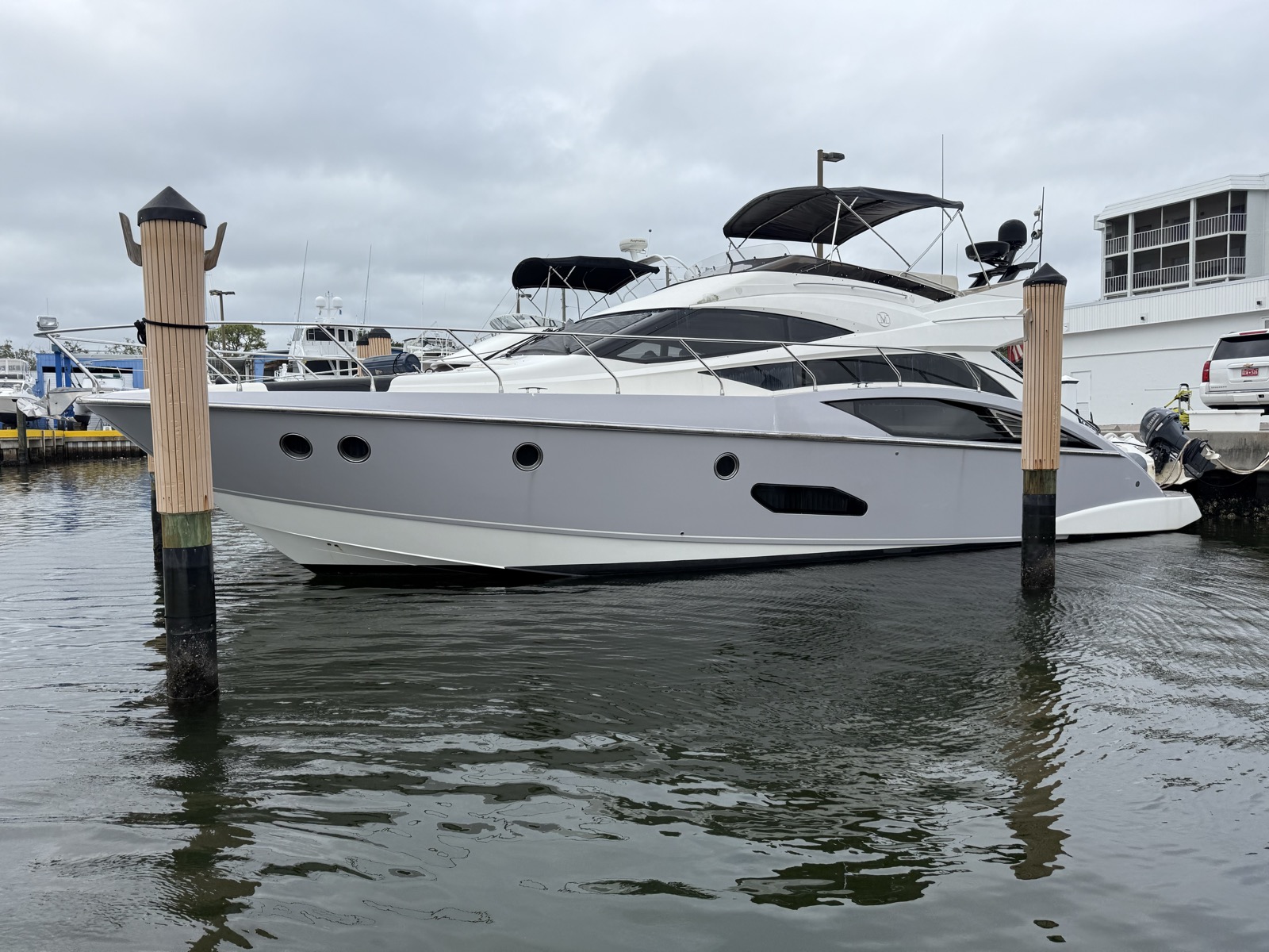 52ft Marquis Flybridge yacht nosed into a slip between wooden pilings